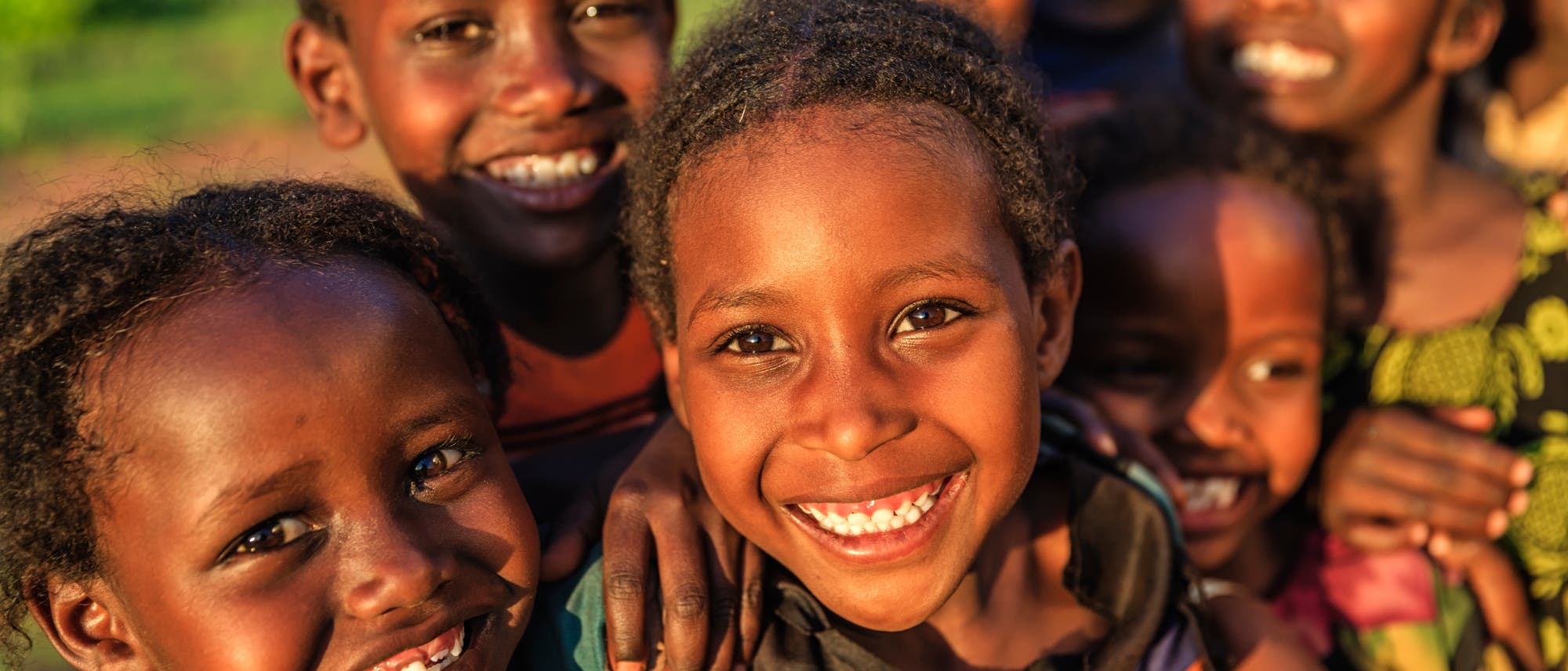Mehrere afrikanische Kinder, die in die Kamera lächeln