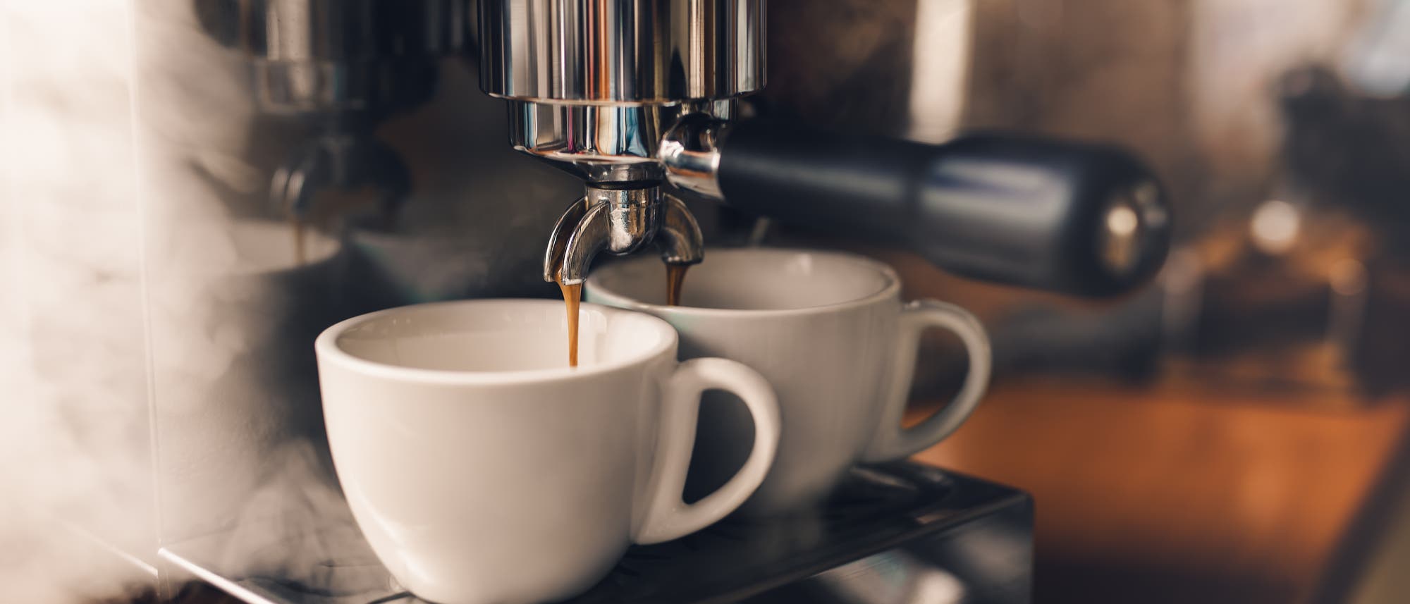 Espresso läuft aus der Maschine in zwei Tassen