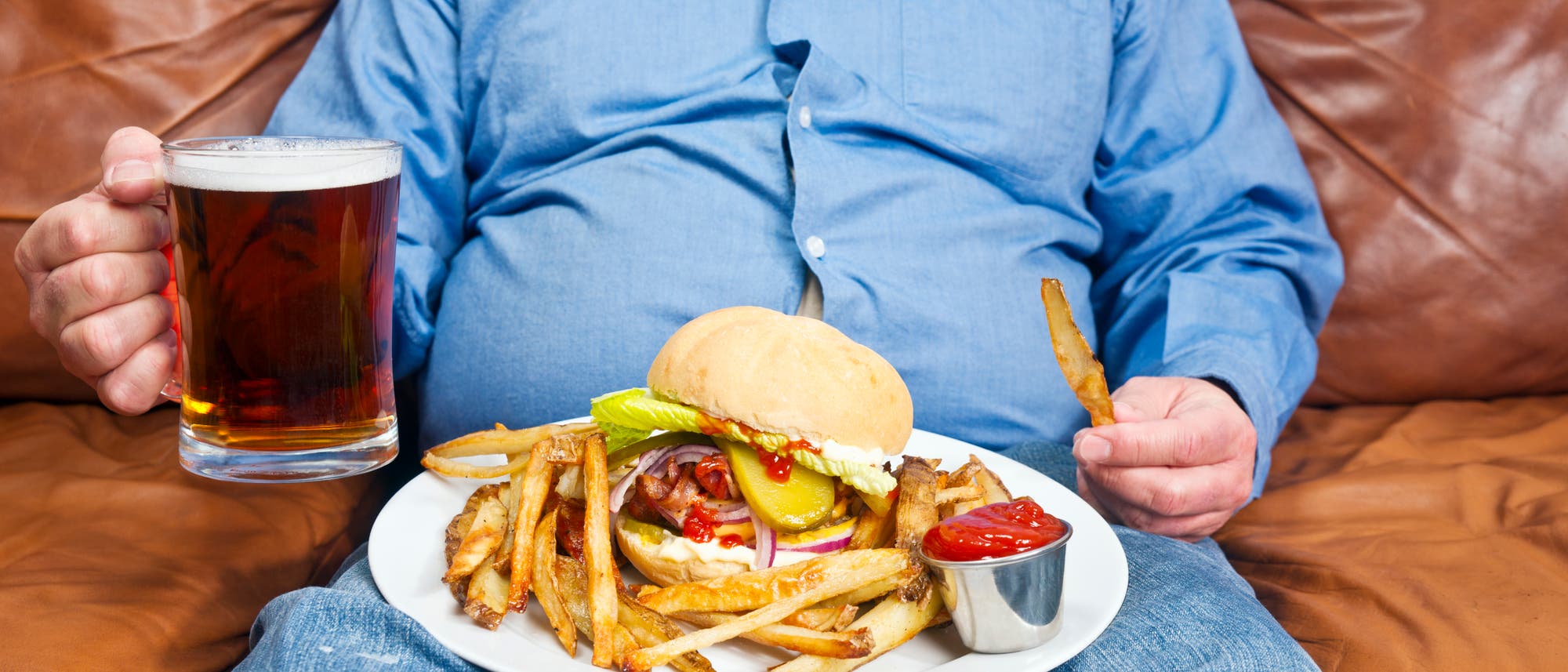 Übergewichtiger Mann isst Burger