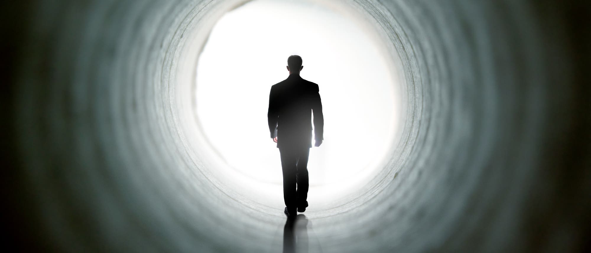 Ein Mann läuft durch einen Tunnel, sieht aber Licht am Ende des Tunnels.
