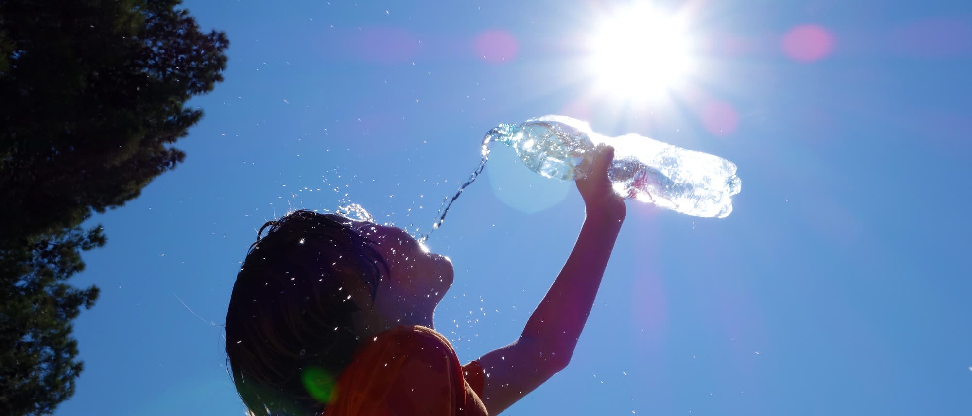 Ein Kind gießt zur Abkühlung Wasser auf sich selbst