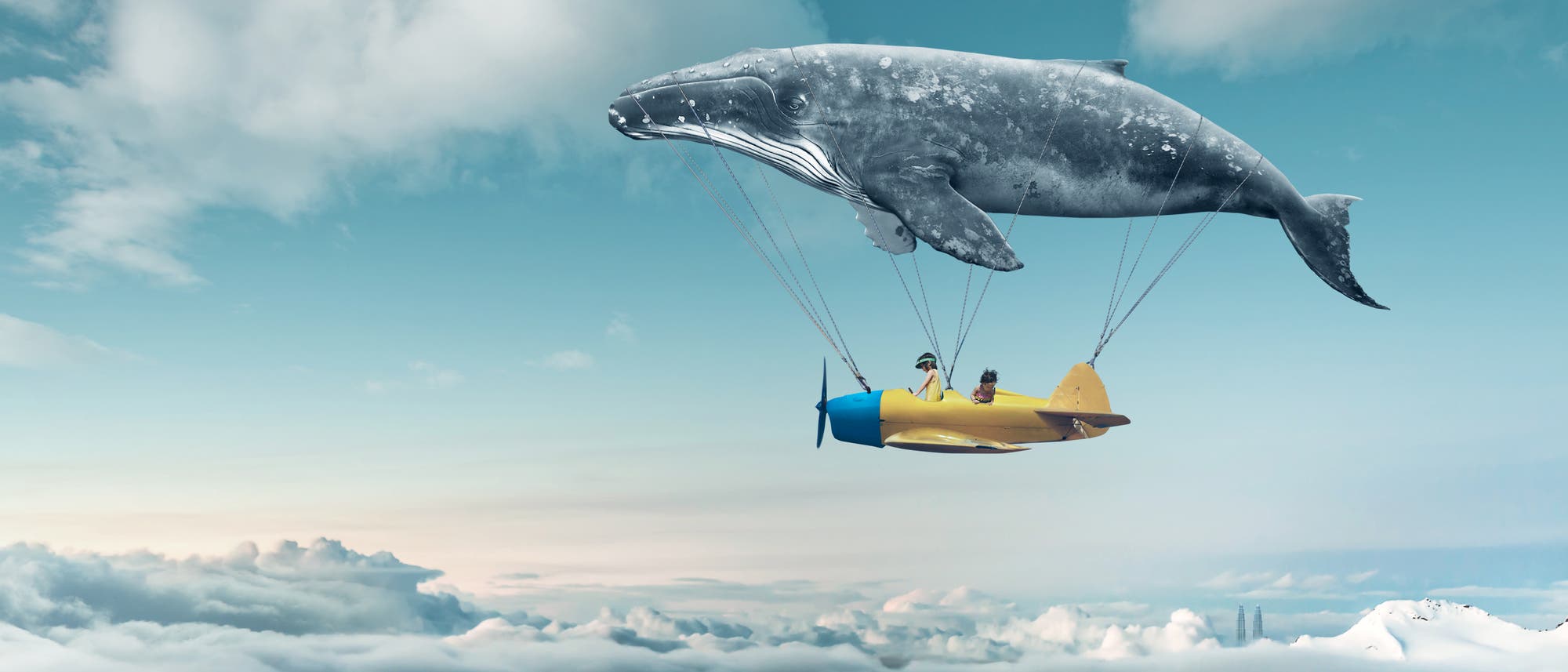 Traumwelt: Kinder in einem Flugzeug über den Wolken, das an einem fliegenden Wal hängt