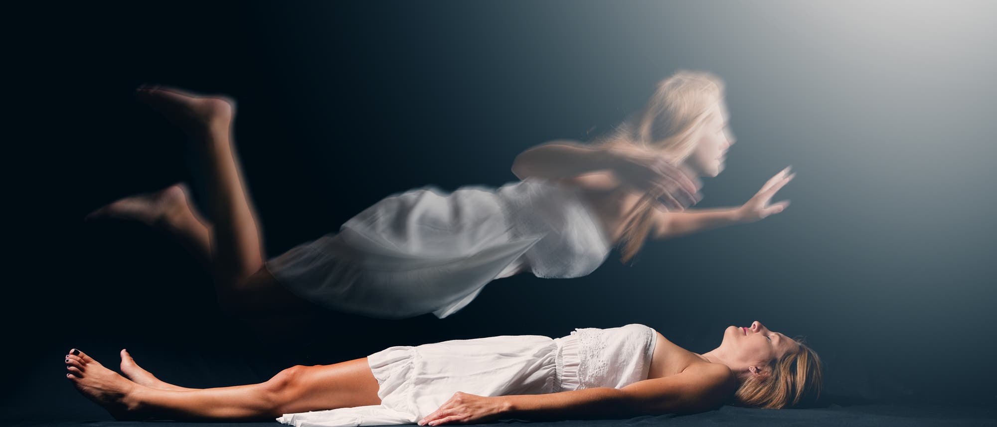 Frau schwebt über ihrem Körper