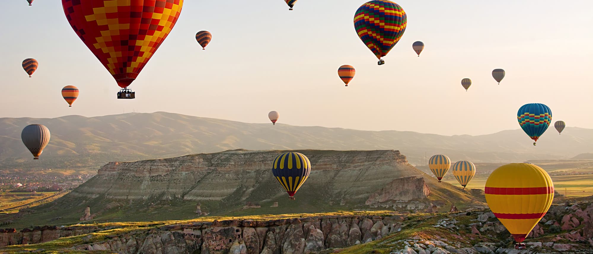 Heißluftballons fliegen über eine Landschaft