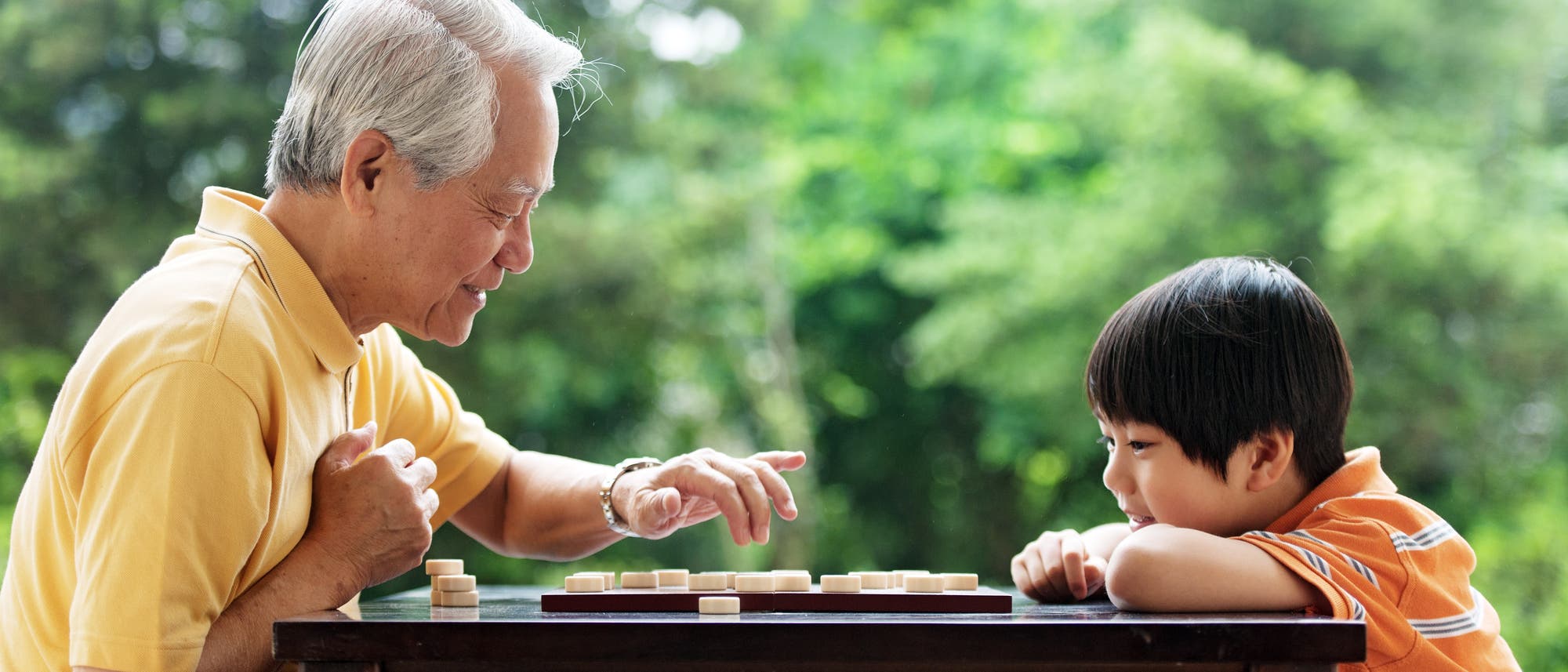 Großvater und Enkelsohn spielen das chinesische Schachspiel Xiangqi