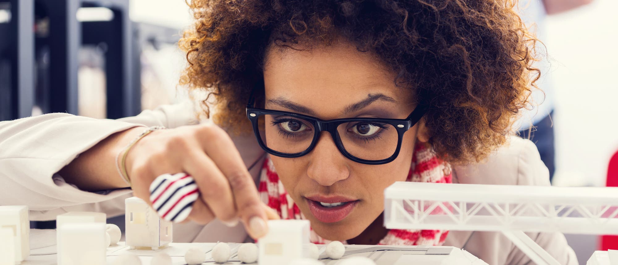 Frau studiert Figuren aus dem 3-D-Drucker