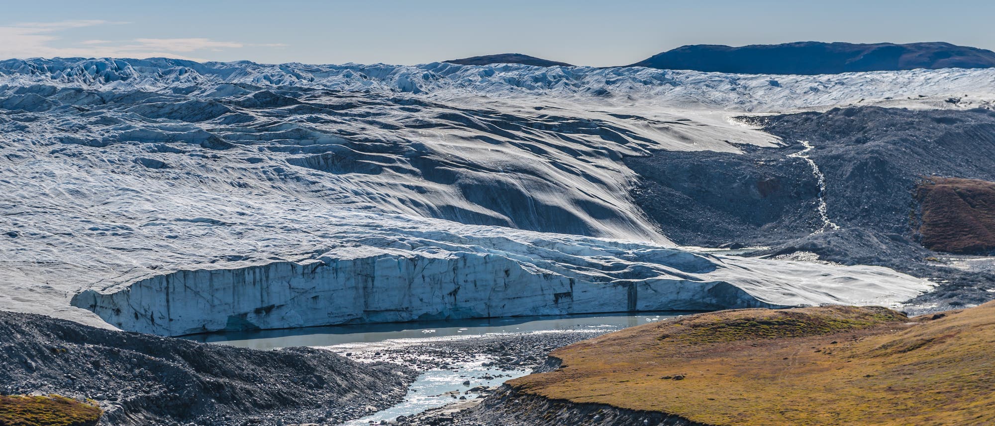 Eine Abbruchkante aus Eis am Rande der Tundra markiert den Rand des grönländischen Inlandeises.