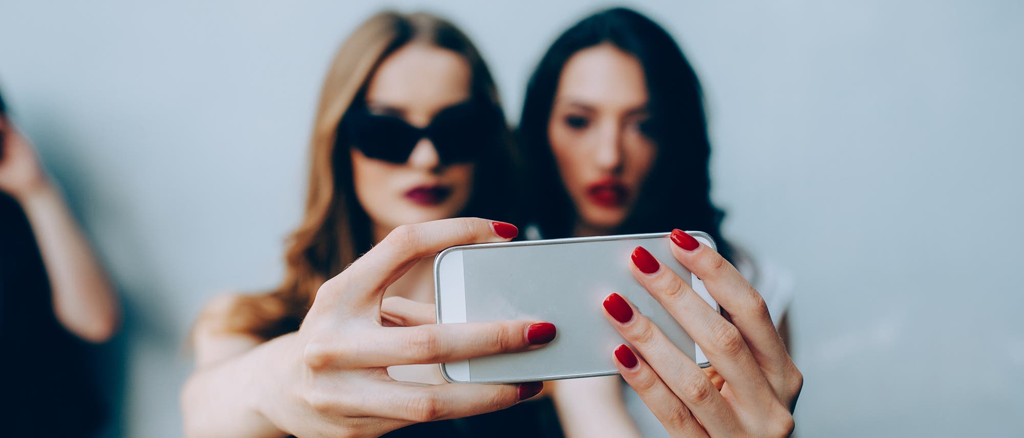 Zwei junge Frauen machen ein Selfie mit ihrem Smartphone
