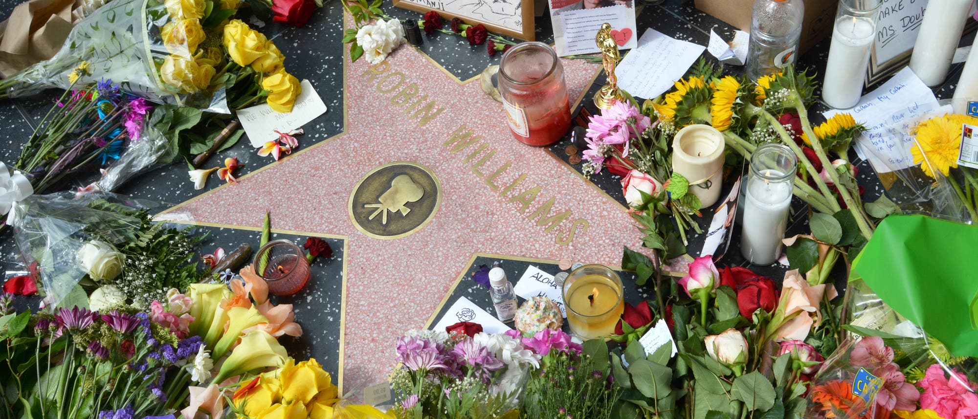 Trauernde legen am Walk of Fame Blumen auf dem Stern von Robin Williams nieder.