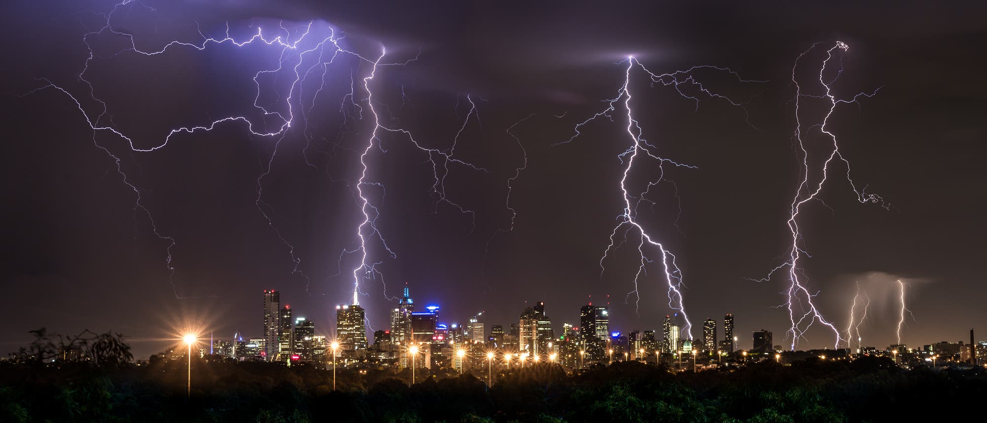 Gewitterblitze &uuml;ber der n&auml;chtlich erleuchteten Gro&szlig;stadt Melbourne.