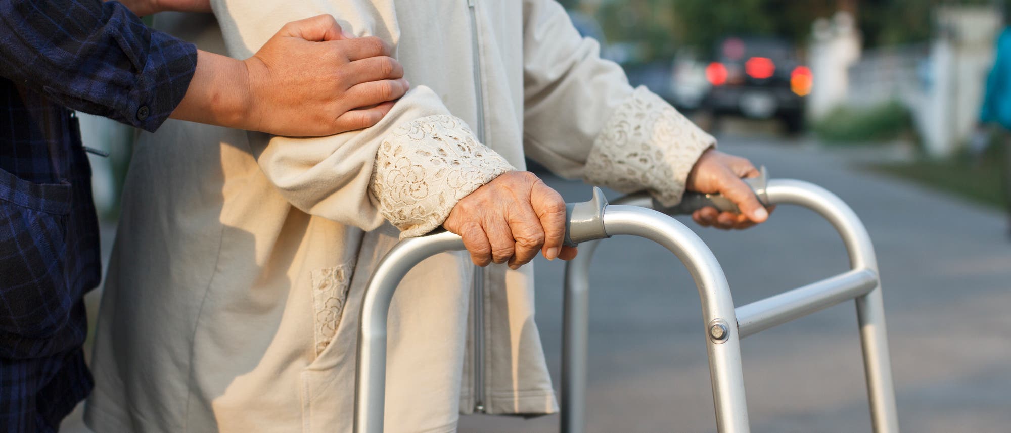 Frau hilft älterer Frau über die Straße