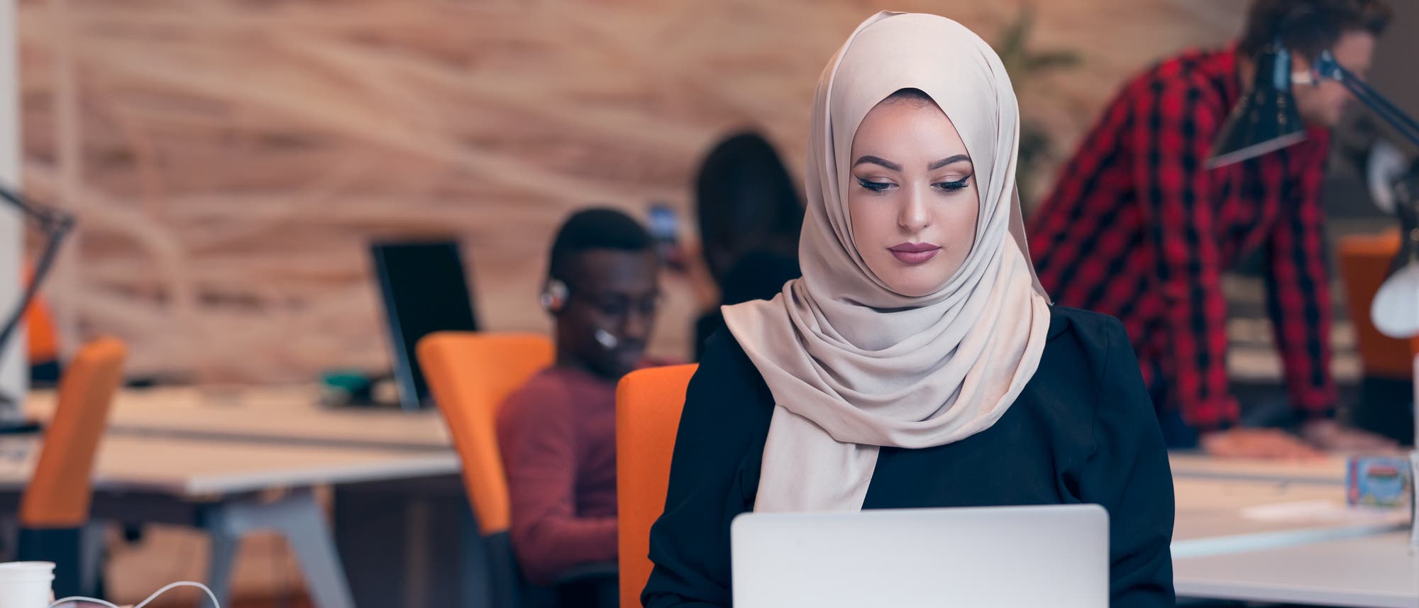 Eine muslimische Frau arbeitet konzentriert am Computer