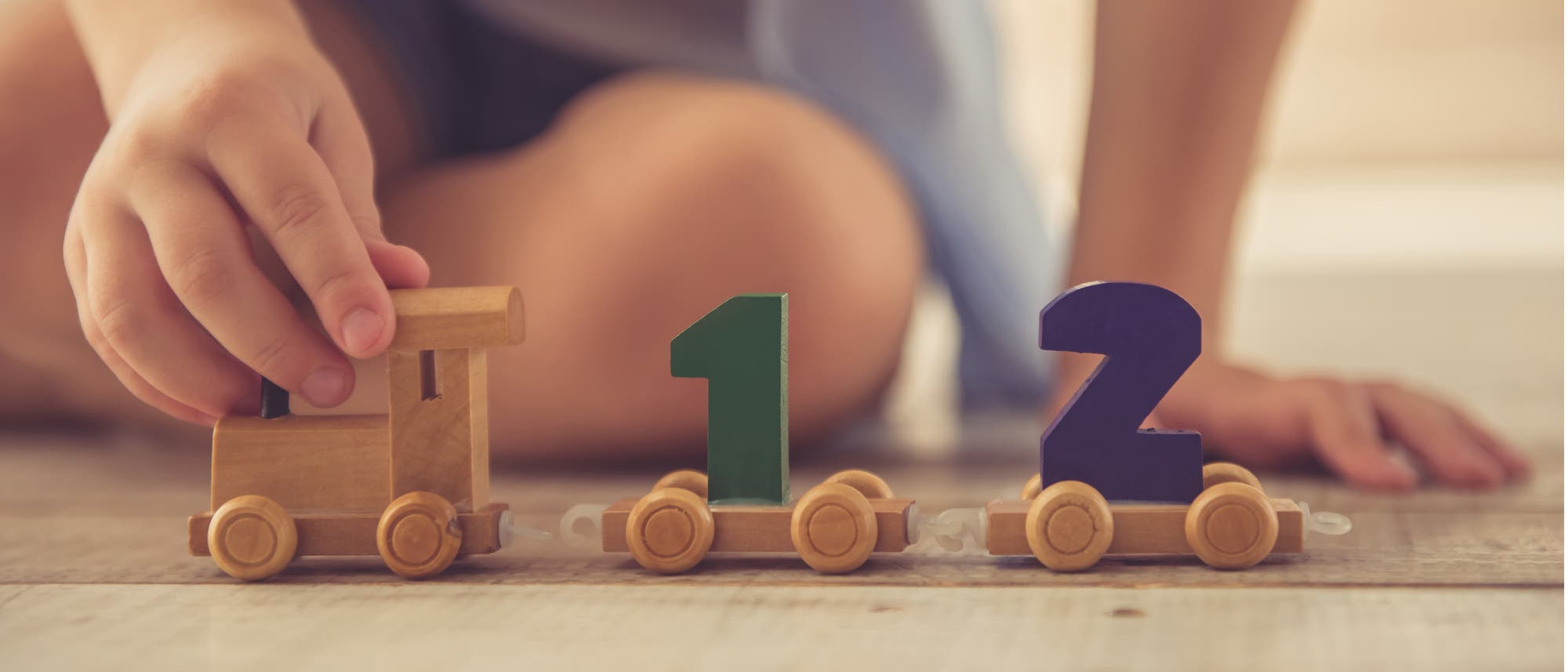 Kind spielt mit einem Zug, auf dem die Zahlen 1 und 2 stehen