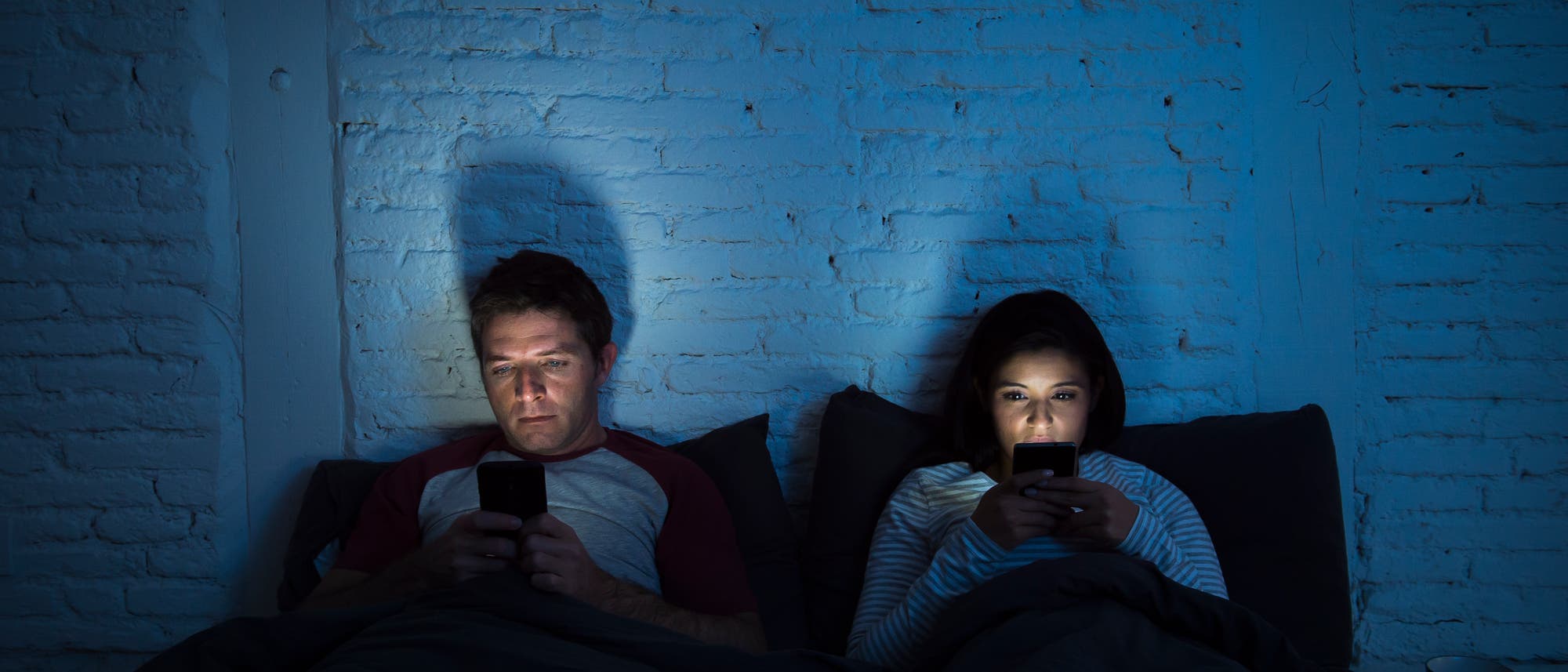 Paar im Bett mit Handy