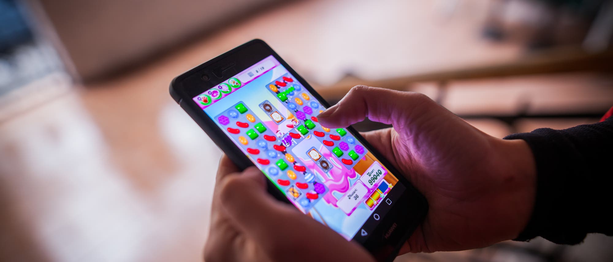 Eine Person spielt Candy Crush auf ihrem Handy