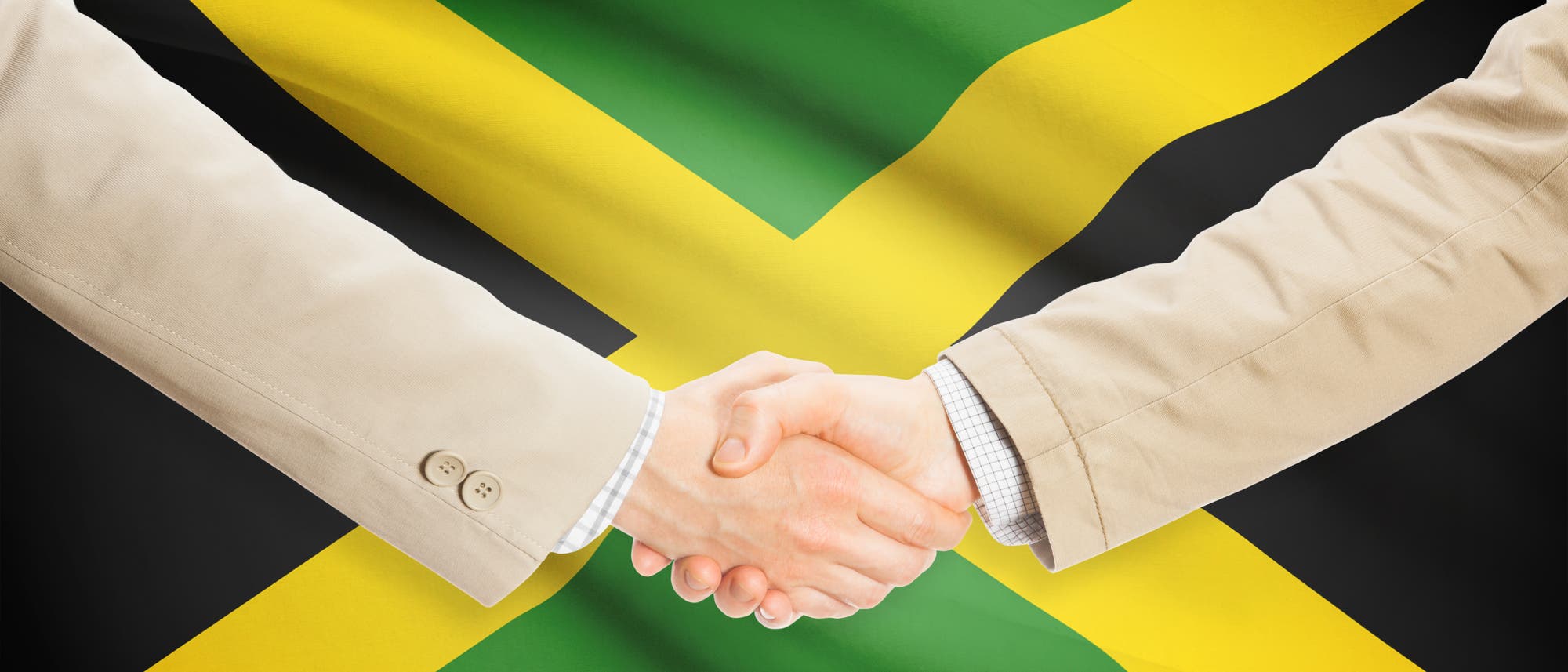 Handschlag vor der Jamaikaflagge