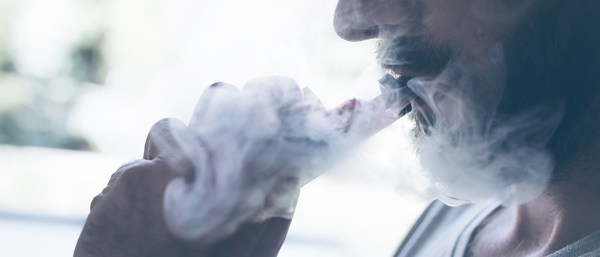 Mann dampft mit einer E-Zigarette