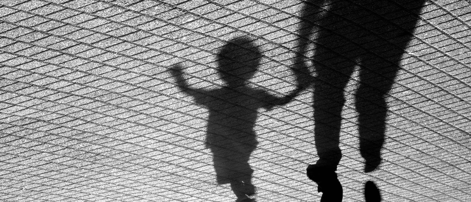 Schatten von einem Kind und einem Erwachsenen