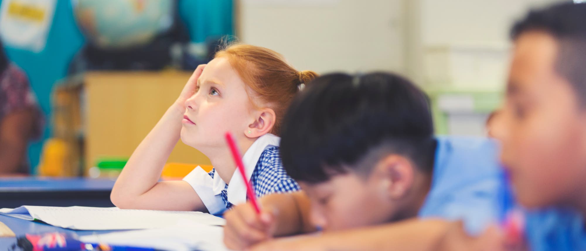 Schulkinder sitzen gelangweilt und müde in einer Klasse. (Symbolbild)