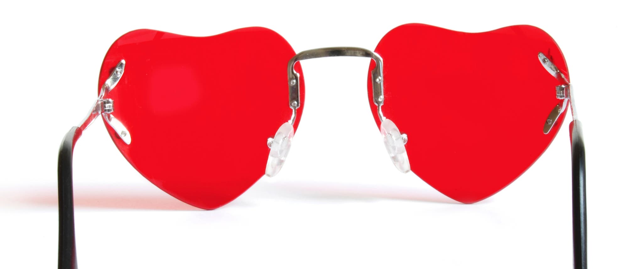 Eine Sonnenbrille mit roten Gläsern, die die Form eines Herzen haben.