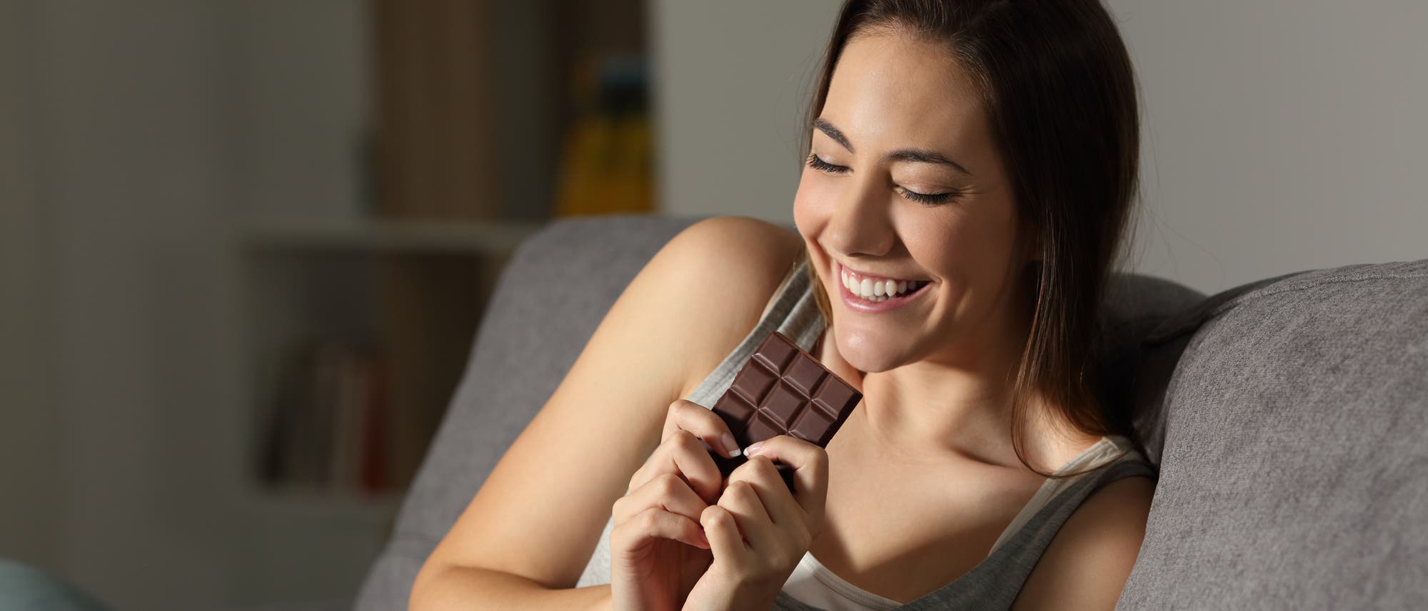 Frau freut sich auf den Genuss einer Tafel Schokolade