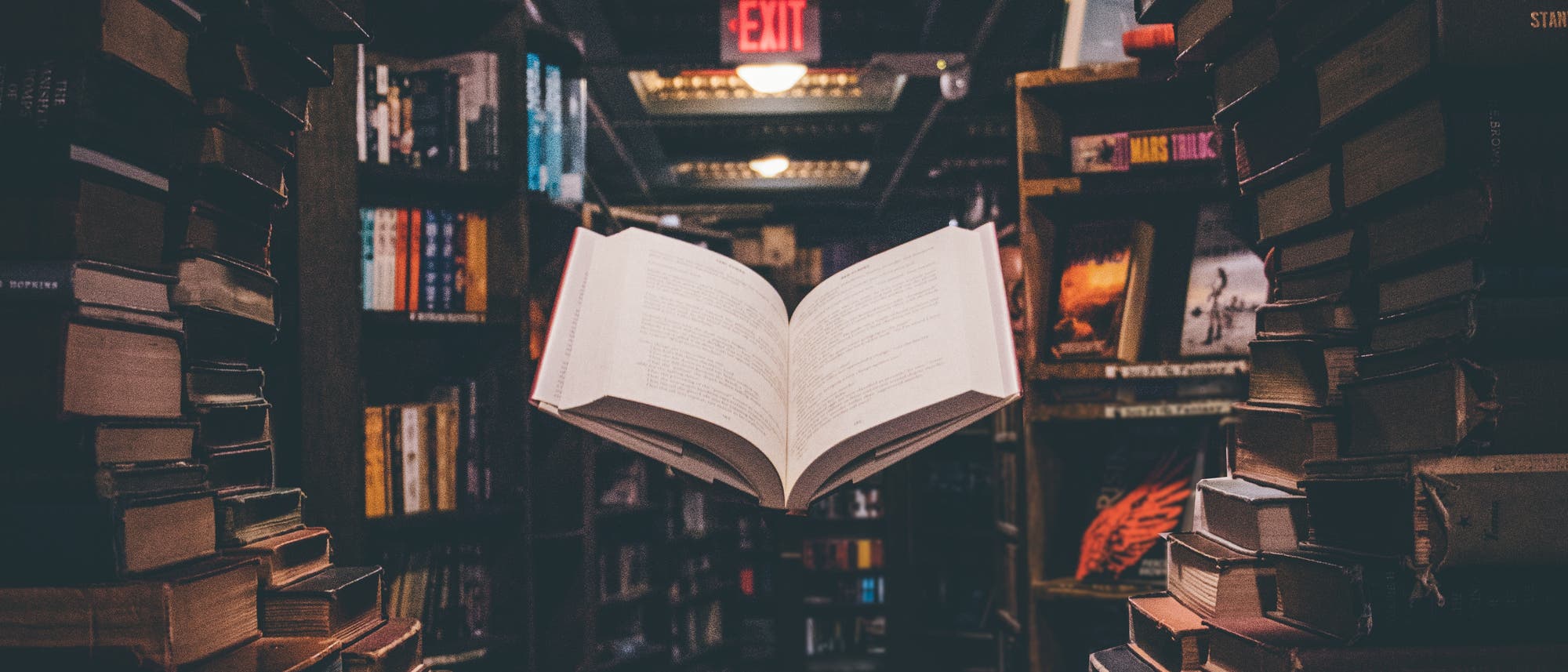 Schwebendes offenes Buch in einem Bücherfenster einer Bibliothek