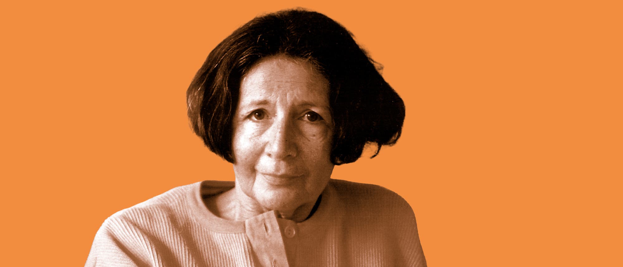 Ein Porträtfoto einer Person vor einem einfarbigen, orangefarbenen Hintergrund. Die Person trägt ein helles Oberteil und blickt direkt in die Kamera. Ein Porträtfoto einer Person vor einem einfarbigen, orangefarbenen Hintergrund. Die Person trägt ein helles Oberteil und blickt direkt in die Kamera.