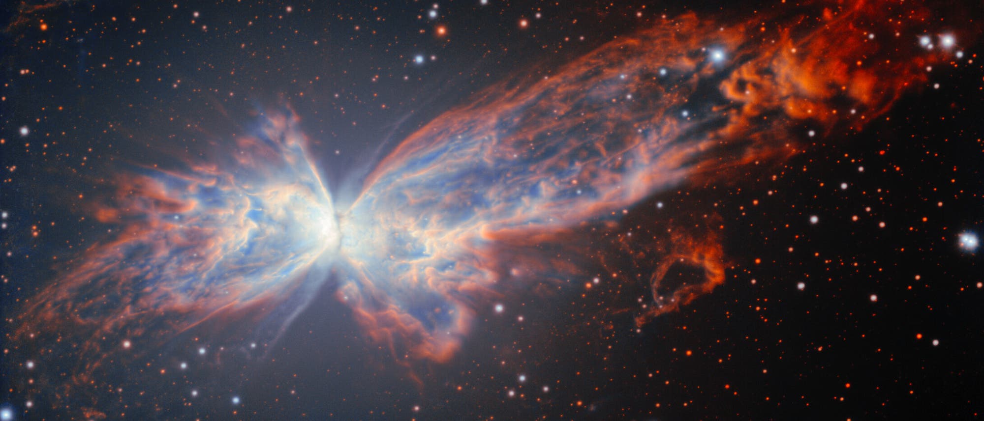Ein farbenfrohes astronomisches Bild zeigt einen Planetarischen Nebel, der wie ein Schmetterling geformt ist. Die leuchtenden Flügel bestehen aus blauen und orangefarbenen Gaswolken, die sich symmetrisch von einem hellen Zentrum ausbreiten. Der Hintergrund ist mit zahlreichen kleinen, leuchtenden Sternen übersät. Das Bild veranschaulicht die Schönheit und Komplexität kosmischer Strukturen.
