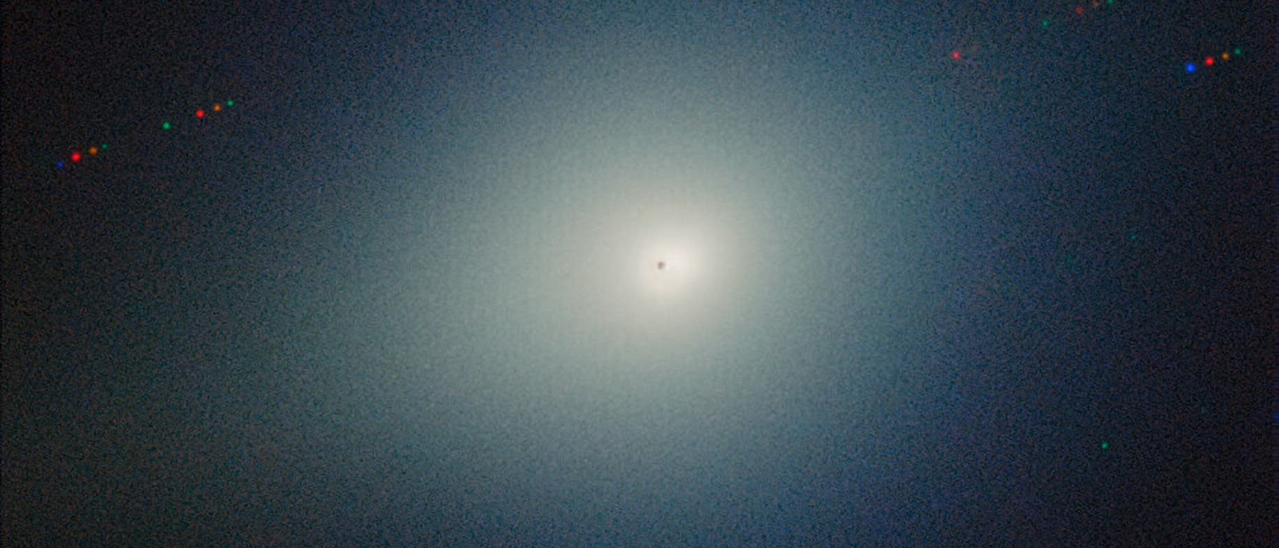 Das astronomisches Bild zeigt den Kometen 3I/ATLAS umgeben von einem hellen Schein, der Koma. Der Hintergrund ist dunkel, mit verstreuten Lichtpunkten, die Sterne darstellen.