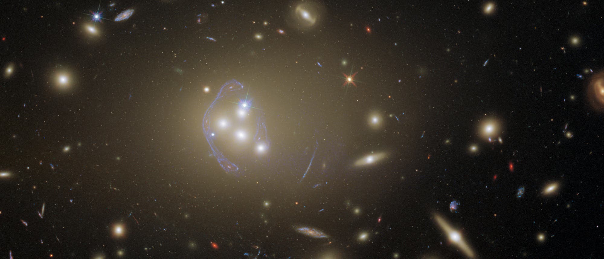 Das Bild zeigt den Galaxienhaufen Abell 3827, der als starke Gravitationslinse wirkt.