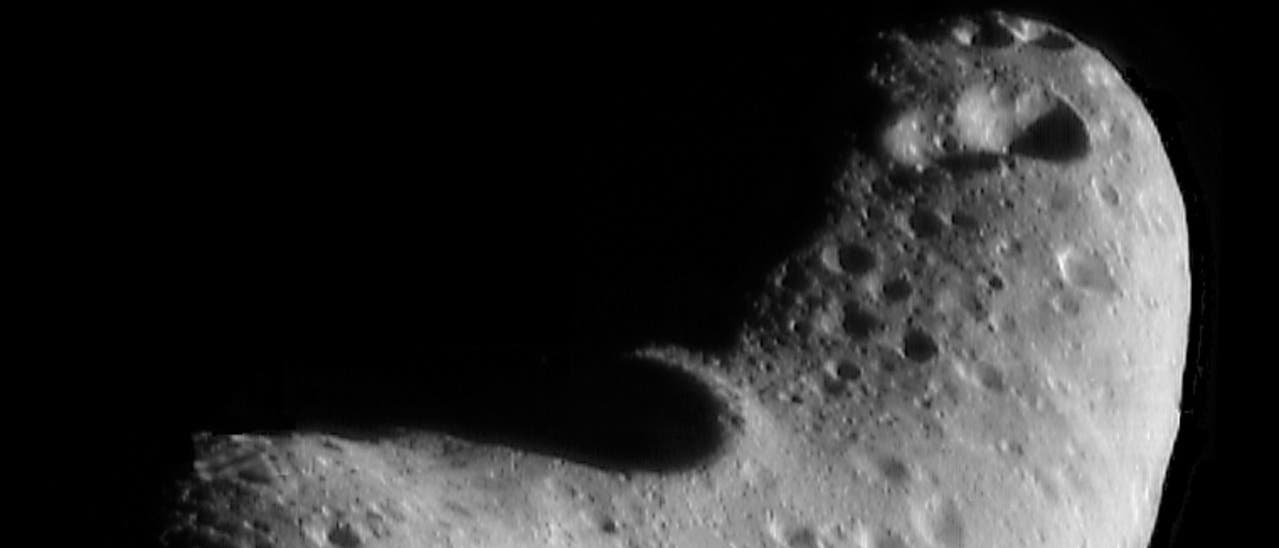 Ein Bild eines unregelmäßig geformten Asteroiden im Weltraum, der von Kratern und Unebenheiten übersät ist. Die Oberfläche ist grau und weist verschiedene Vertiefungen und Erhebungen auf, die auf Einschläge hinweisen. Der Asteroid hebt sich deutlich vor dem schwarzen Hintergrund des Weltraums ab. Ein Bild eines unregelmäßig geformten Asteroiden im Weltraum, der von Kratern und Unebenheiten übersät ist. Die Oberfläche ist grau und weist verschiedene Vertiefungen und Erhebungen auf, die auf Einschläge hinweisen. Der Asteroid hebt sich deutlich vor dem schwarzen Hintergrund des Weltraums ab.