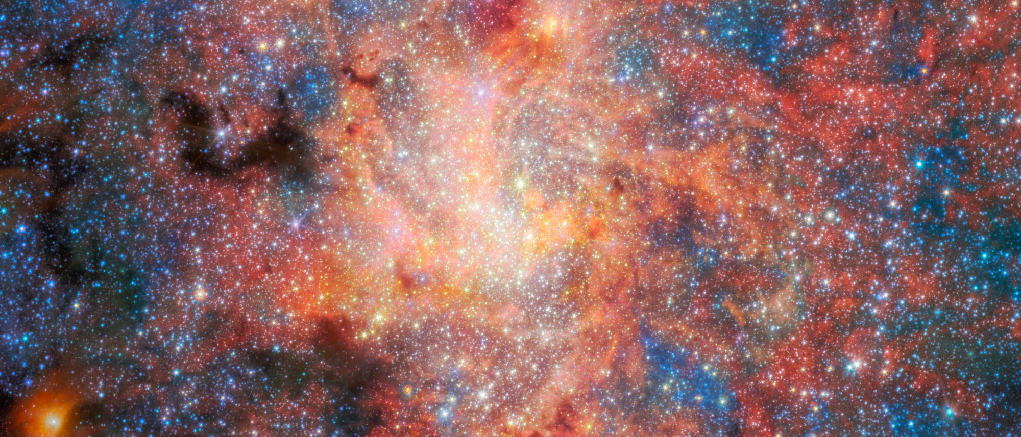 Ein farbenprächtiges astronomisches Bild zeigt eine dichte Ansammlung von Sternen und kosmischem Staub. Die Farben reichen von leuchtendem Rot und Orange bis zu kühlem Blau, was auf verschiedene Gase und Temperaturen hinweist. Im Zentrum ist eine helle, strahlende Region zu sehen, die möglicherweise einen Sternhaufen oder eine Galaxie darstellt. Das Bild vermittelt die Weite und Komplexität des Universums. Ein farbenprächtiges astronomisches Bild zeigt eine dichte Ansammlung von Sternen und kosmischem Staub. Die Farben reichen von leuchtendem Rot und Orange bis zu kühlem Blau, was auf verschiedene Gase und Temperaturen hinweist. Im Zentrum ist eine helle, strahlende Region zu sehen, die möglicherweise einen Sternhaufen oder eine Galaxie darstellt. Das Bild vermittelt die Weite und Komplexität des Universums.