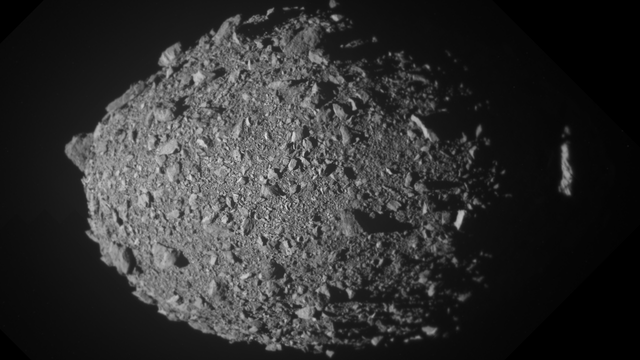 In diesem aus mehreren Bildern zusammengesetzten Bild ist der Asteroidenmond Dimorphos kurz vor dem Aufprall der DART-Sonde zu sehen. Der Asteroid ähnelt einem eierförmigen, losen Schutthaufe aus kleinen Steinen und Geröll. Die Aufnahme ist in schwarz/weiß.