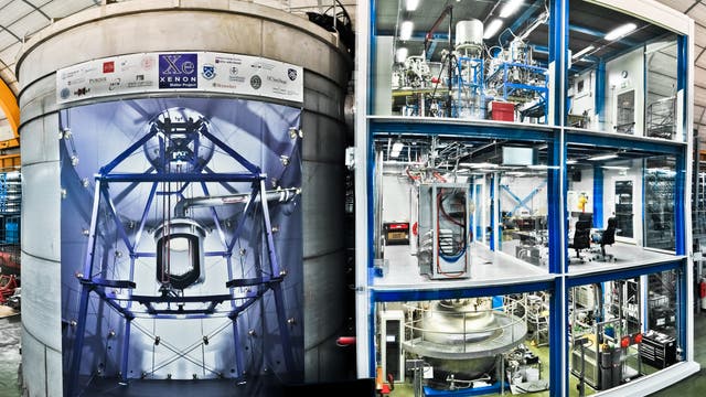 Wassertank und Gerätehaus von XENON1T - auf dem Tank ist eine Innenansicht des Tanks mit dem in der Mitte aufgehängten Detektor aufgedruckt.