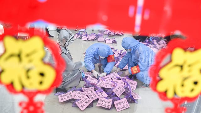 Coronavirus-Epidemie in China:Drei Personen in Schutzanzügen sortieren Versorgungsgüter für Menschen in Quarantäne.
