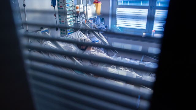 Eine an Covid-19 erkrankte Patientin liegt in einem Zimmer des besonders geschützten Teils einer Intensivstation. 