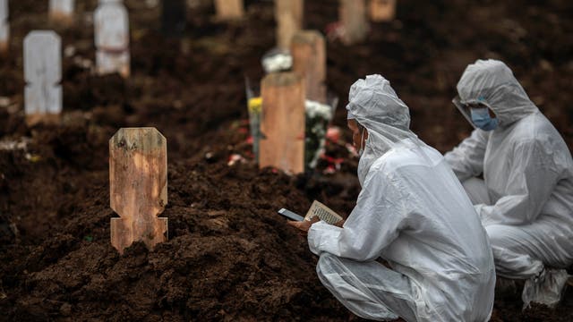 Ein Kleriker spricht das letzte Gebet für einen Menschen, der an den Folgen von Covid 19 in Süd-Jakarta, Indonesien, gestorben ist.