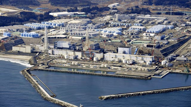 Luftbild des havarierten Kernkraftwerks Fukushima Daiichi mit Wassertanks im Hintergrund.