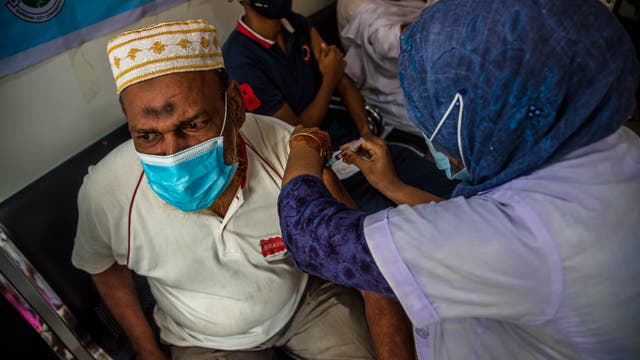 Barishal, Bangladesch: Eine Mitarbeiterin des Gesundheitssystems impft einen Mann während einer Massenimpfung mit Moderna.