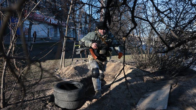 Ein Freiwilliger der Territorialverteidigung kommt aus einem mit Molotowcocktails gefüllten Graben, der entlang einer Allee gegenüber dem nationalen Fernsehen in Kiew ausgehoben wurde. (1. März 2022)