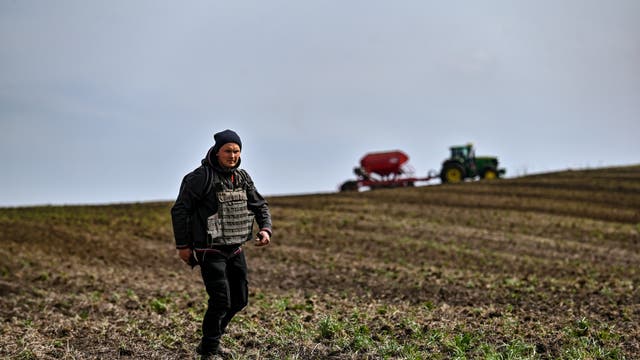 Ein Landwirt trägt eine kugelsichere Weste während der Aussaat, die 30 Kilometer von der Frontlinie entfernt stattfindet, Region Zaporizhzhia, Südostukraine.