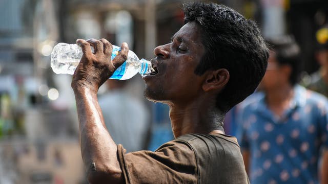 Ein Mann trinkt Wasser, um die Folgen der Hitzewelle in Indien etwas zu lindern.