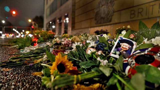 Blumen und ein Foto von Elisabeth II. vor der britischen Botschaft