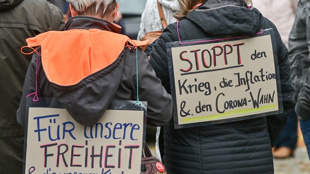 Zwei Frauen tragen Plakate mit der Aufschrift «Für unsere Freiheit und die unserer Kinder» und «Stoppt den Krieg, die Inflation und den Corona-Wahn» bei einer Demonstration in Frankfurt (Oder) am 03.10.2022.