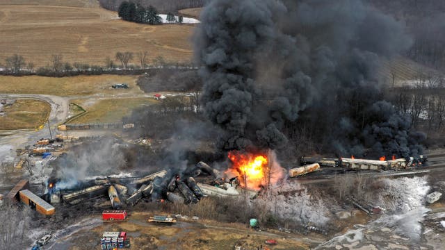 Eine Luftbildaufnahme zeigt die Ausmaße des Zugunglücks: Die Waggons des Güterzugs sind entgleist und haben sich ineinandergeschoben. Einige Waggons stehen in Flammen und es sind schwarze Rauchwolken zu sehen.