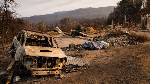Ein zerstörtes Auto ist die Folge eines Waldbrandes in Chile.
