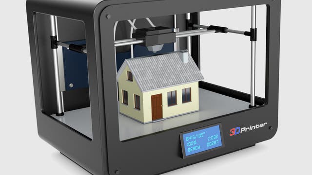 Ein stilisiertes Haus in einem 3-D-Drucker
