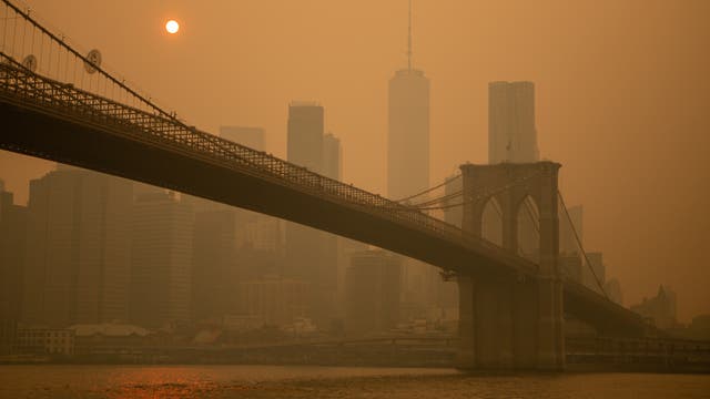 Die Brooklyn Bridge im Rauch vor gelbem Himmel.