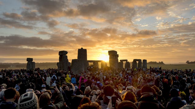 Tausende Menschen haben sich um das Stonehenge-Monument versammelt und machen Bilder vom Sonnenaufgang