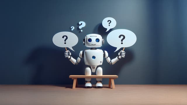 Ein kleiner, freundlicher Roboter sitzt auf einer Bank in einem schlichten Raum und hält zwei Sprechblasen mit Fragezeichen. Im Hintergrund sind weitere Fragezeichen zu sehen. Das Bild symbolisiert Neugier und das Stellen von Fragen.